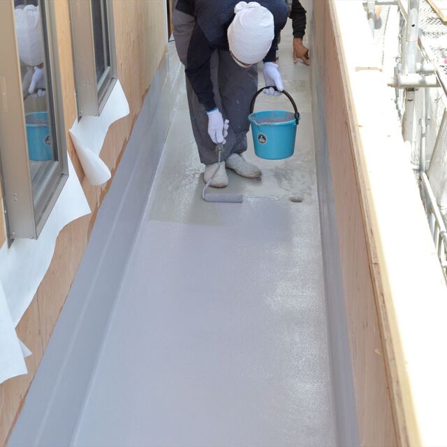 ベランダ床の防水工事を行う職人jpg